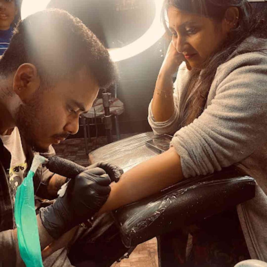 Tattoo artist souvik das creating a tattoo at dark shader tattoo studio in a clean and hygienic environment.