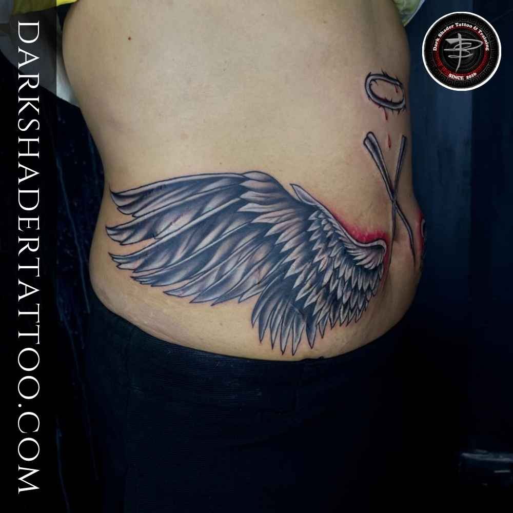 A bold eagle wing tattoo on a girl’s lower belly, showing a powerful and artistic tattoo design.