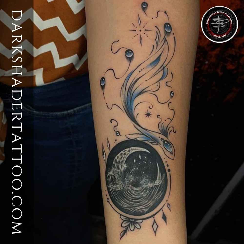 A unique fish and moon combination tattoo on a girl’s hand, featuring an artistic and creative design.