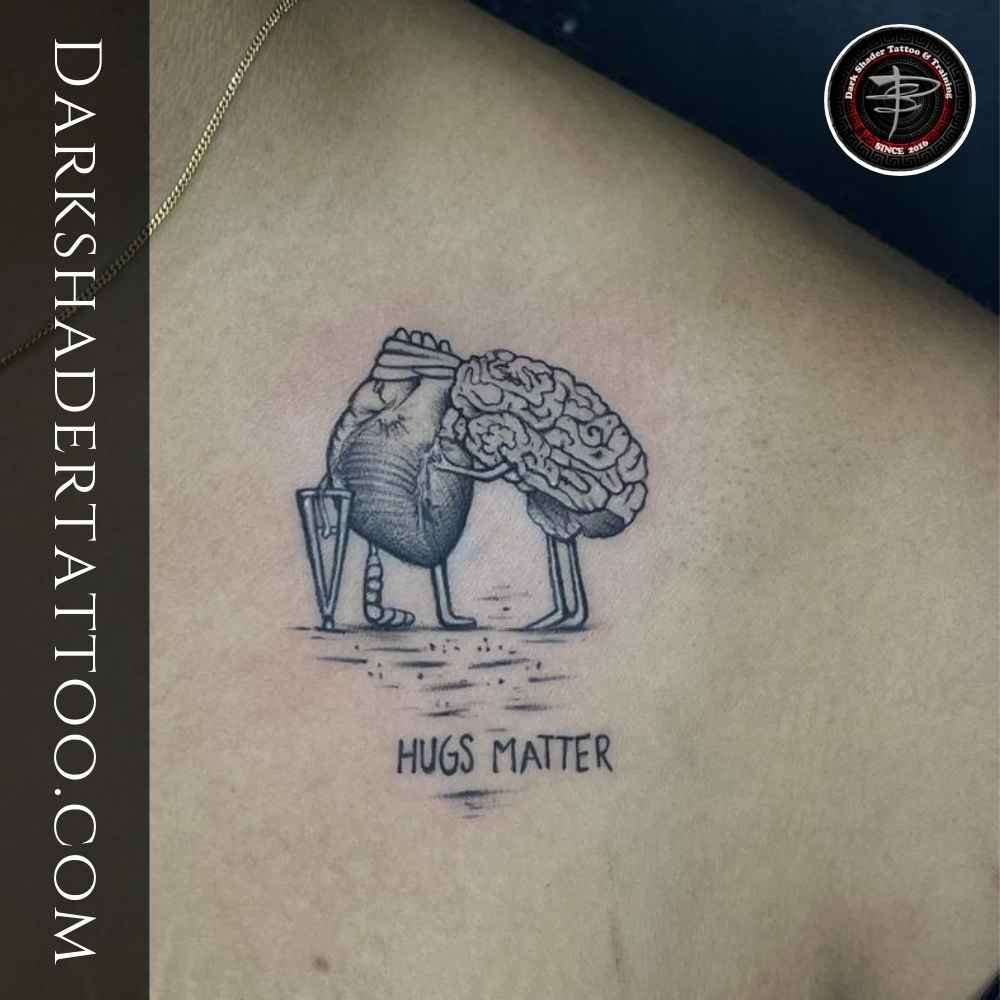 A small tattoo of a brain and heart hugging, designed on a girl’s chest.