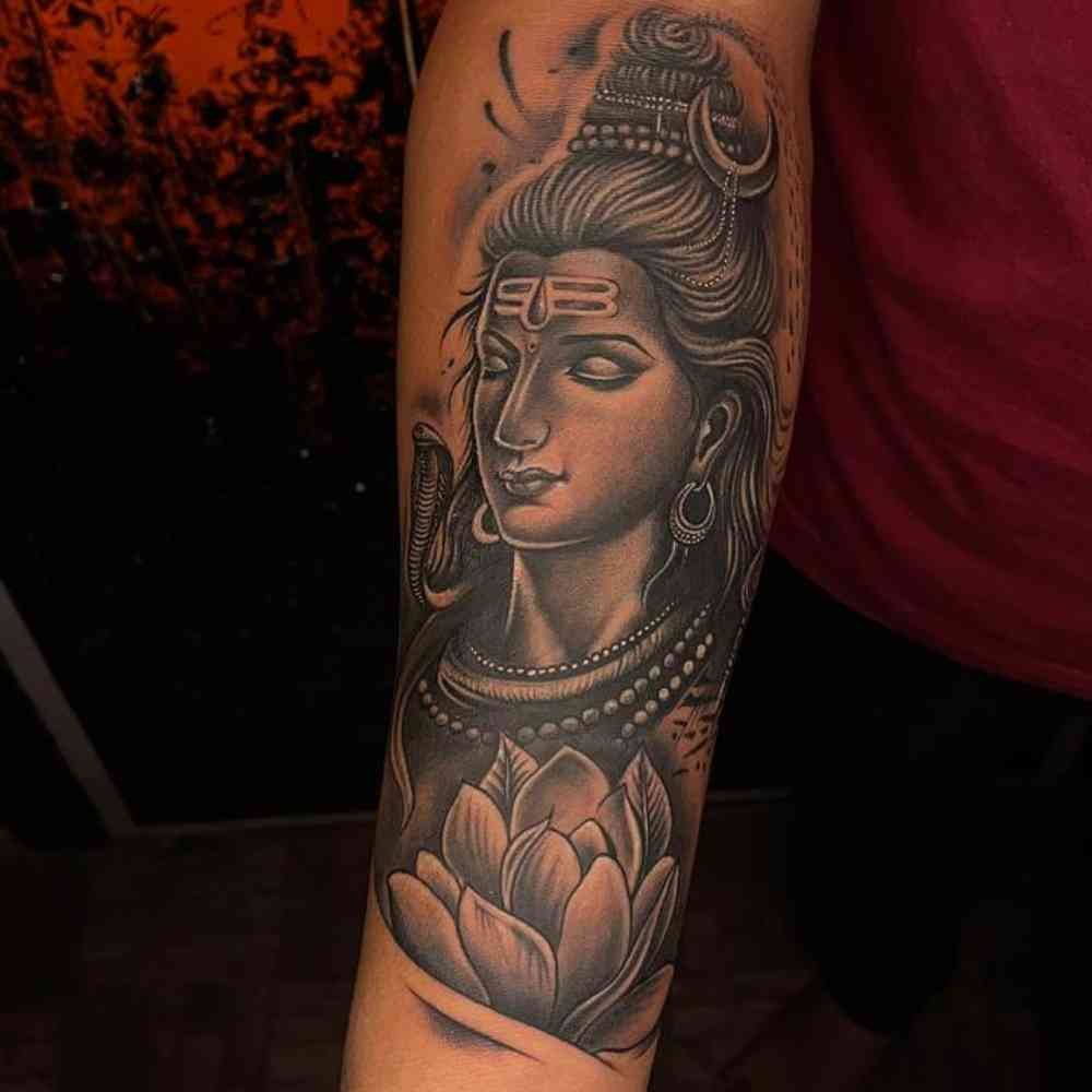 Peaceful face of mahadev tattoo. Snake covered on kneck and lotus below. Full hand realistic tattoo