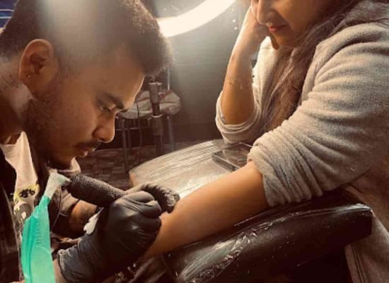 Tattoo artist souvik das creating a tattoo at dark shader tattoo studio in a clean and hygienic environment.